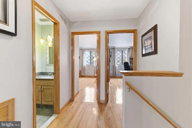 a view of a hallway with wooden floor and living room