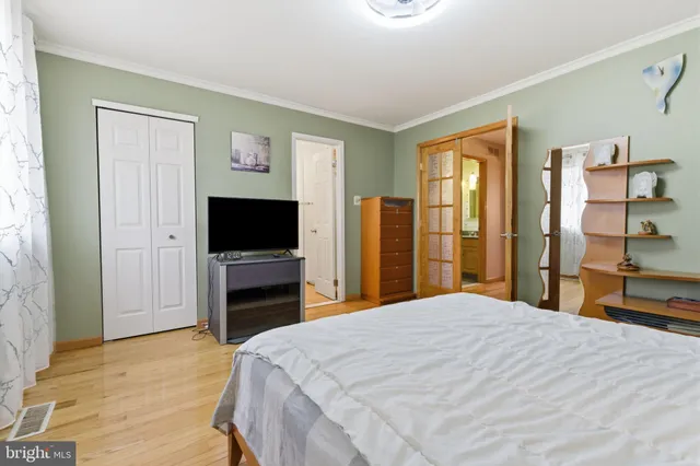 a bedroom with a bed and a flat screen tv