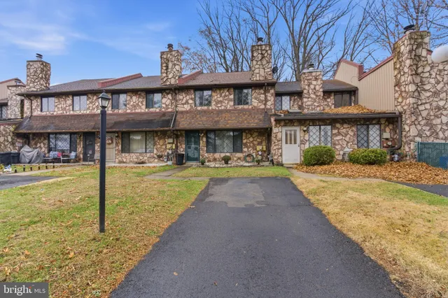 a front view of a building with a garden and plants
