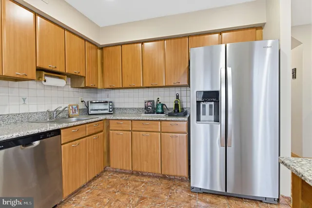 a kitchen with stainless steel appliances granite countertop a refrigerator sink and cabinets