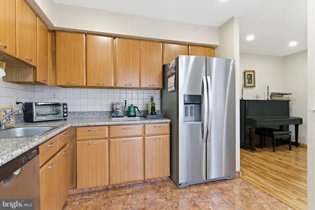 a kitchen with stainless steel appliances granite countertop a refrigerator and a stove top oven