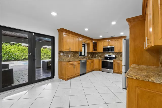 a kitchen with stainless steel appliances granite countertop a refrigerator and a sink