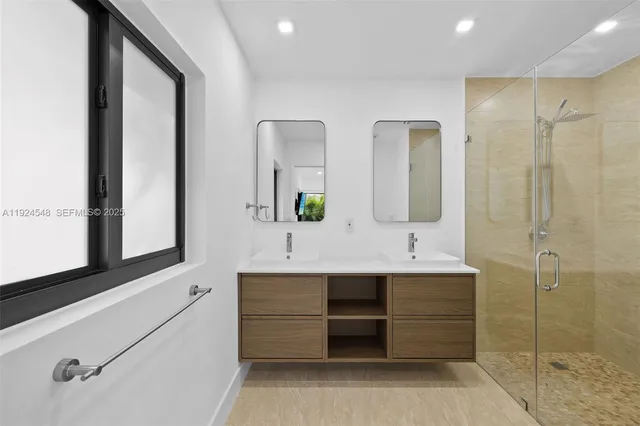 a bathroom with a double vanity sink mirror and bathtub