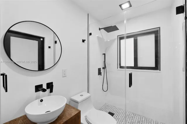 a bathroom with a sink a toilet and a mirror