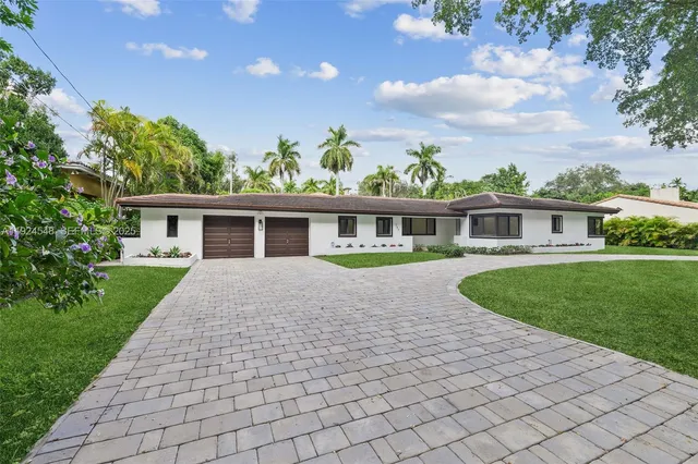 a front view of a house with a garden