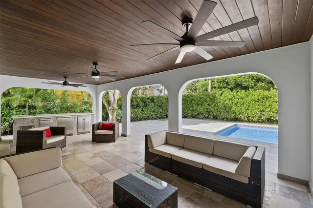 a living room with patio furniture and a floor to ceiling window