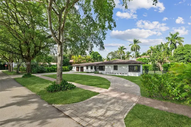 a front view of a house with a yard and trees