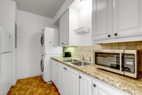 a kitchen with granite countertop a sink stainless steel appliances and cabinets