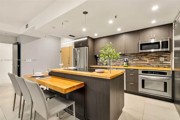 a kitchen with stainless steel appliances granite countertop a stove a sink and a microwave