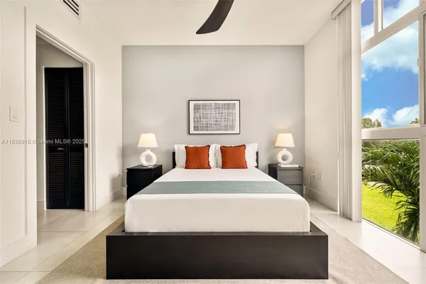 a large bed sitting in a bedroom next to a window