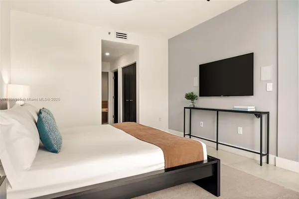 a bedroom with a bed and a flat screen tv