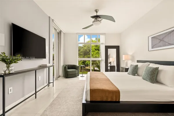 a bedroom with a large bed and a flat screen tv