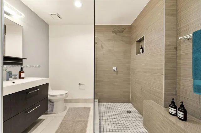 a bathroom with a sink a toilet a mirror and shower