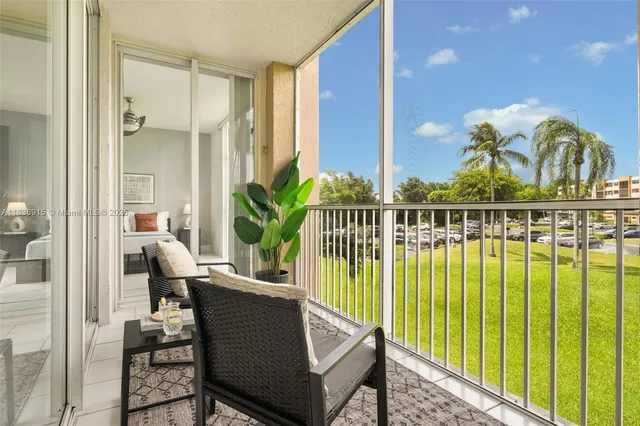 a view of balcony with two chairs and a potted plant