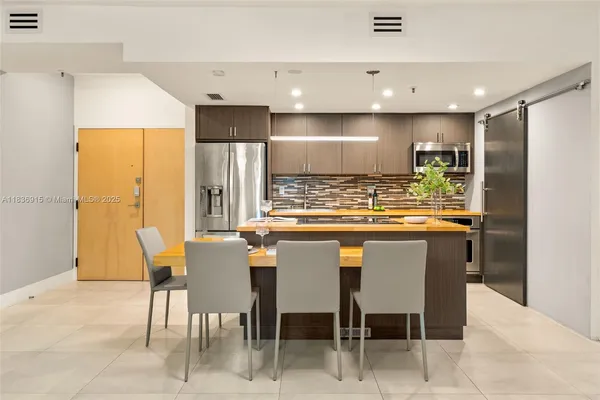 a kitchen with stainless steel appliances granite countertop a table and chairs