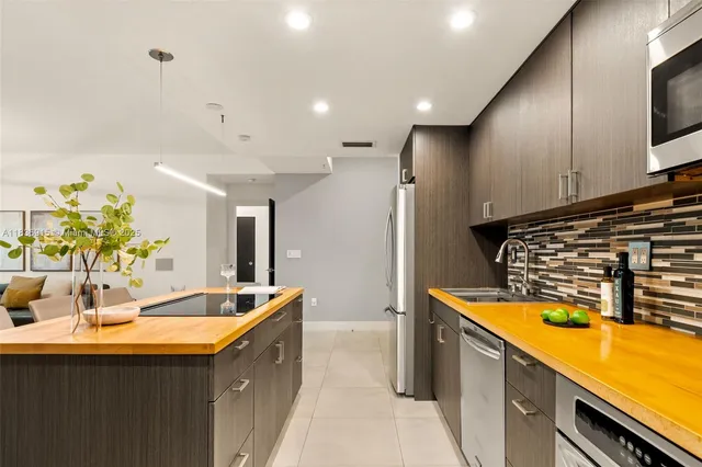 a kitchen with stainless steel appliances a sink a stove and a refrigerator