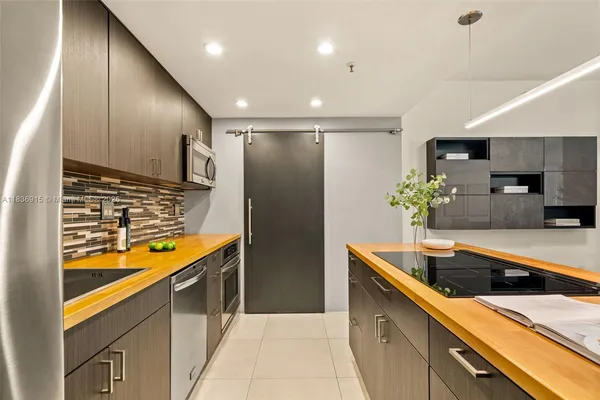 a kitchen with stainless steel appliances granite countertop a sink and a refrigerator