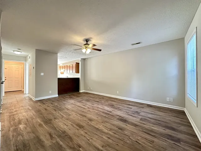 an empty room with wooden floor and chandelier