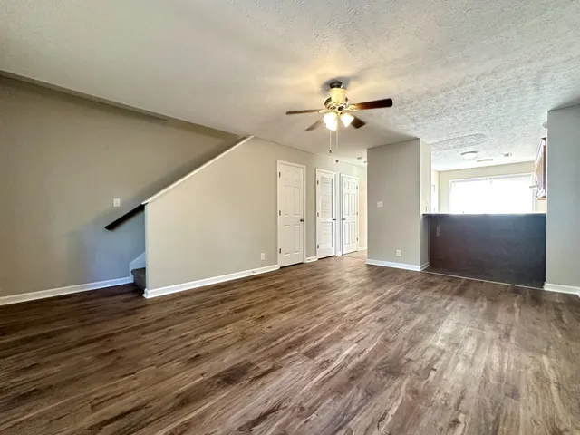 an empty room with wooden floor and ceiling fan