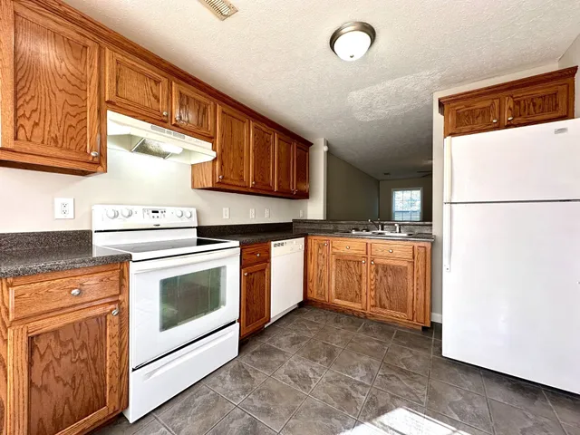 a kitchen with white cabinets and white appliances