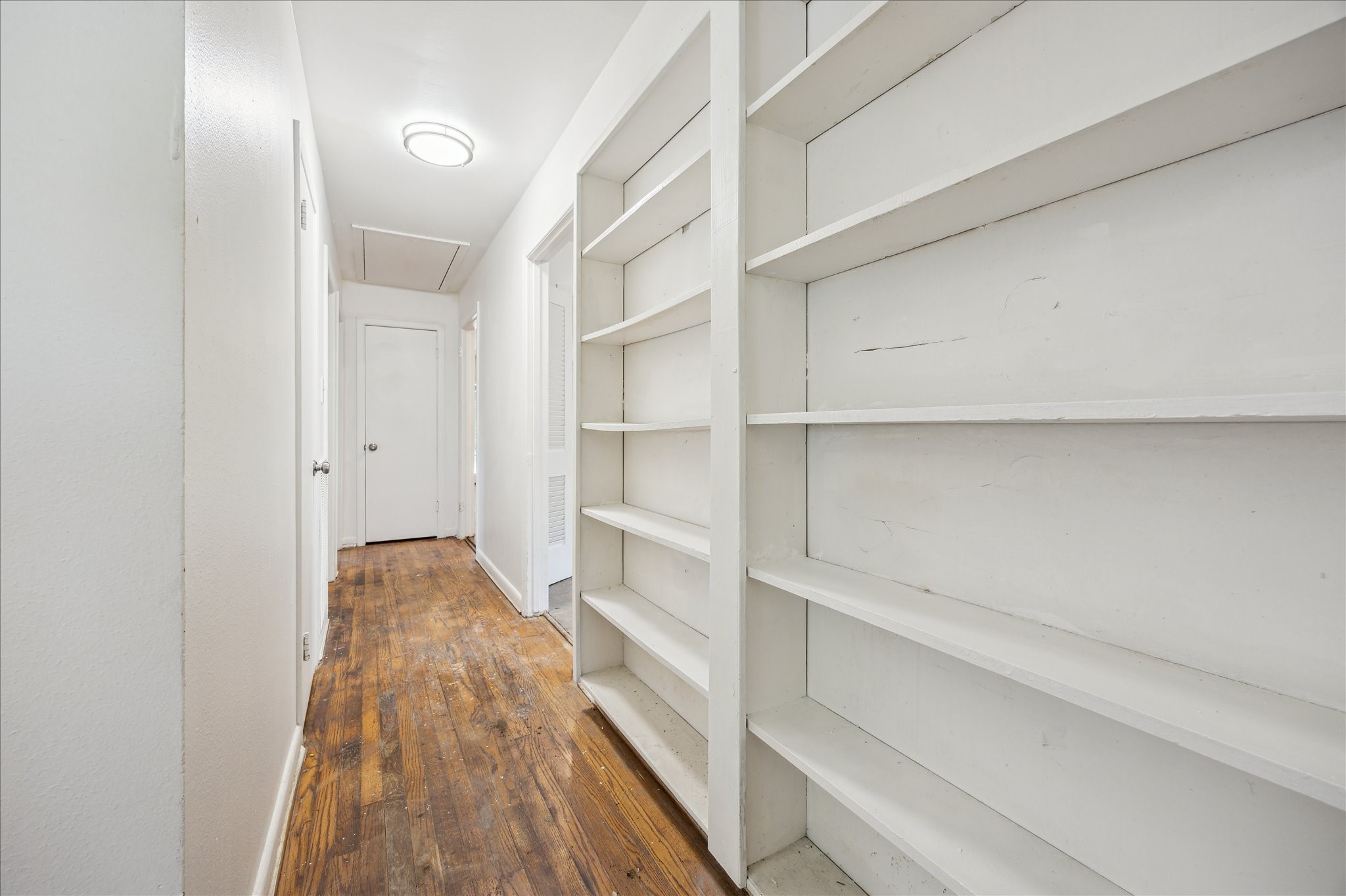 5419 Beechnut Street Houston, TX 77096 - Photo 15 of 28 Hallway with wood flooring and built-in shelving, offering convenient storage and display space.