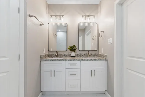a bathroom with a granite countertop sink and a mirror