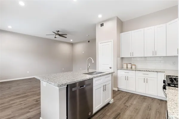 a kitchen with a sink cabinets and wooden floor