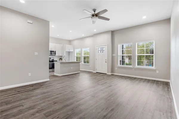 a view of an empty room with a window and wooden floor