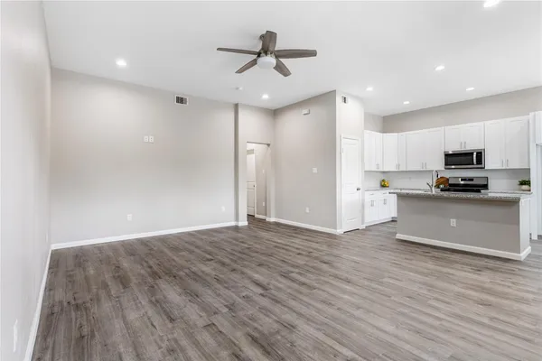 a view of kitchen with granite countertop cabinets and refrigerator
