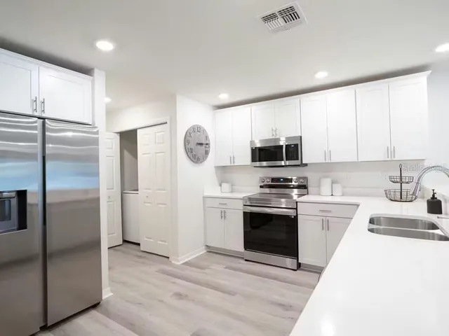 a kitchen with stainless steel appliances granite countertop a refrigerator stove and sink