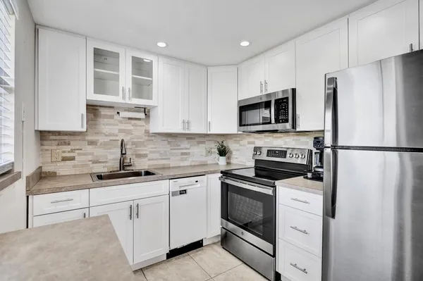 a kitchen with cabinets stainless steel appliances and a sink