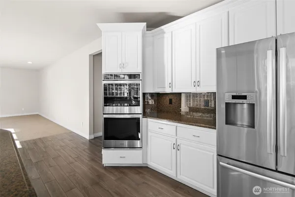 a kitchen with stainless steel appliances a refrigerator stove and cabinets