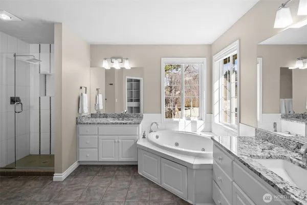 a bathroom with a granite countertop tub sink and mirror