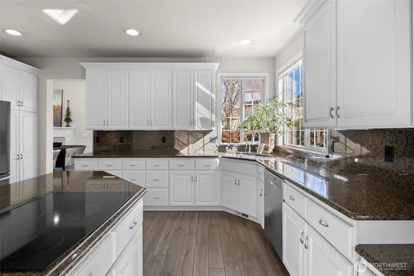 a kitchen with stainless steel appliances granite countertop a sink stove and cabinets