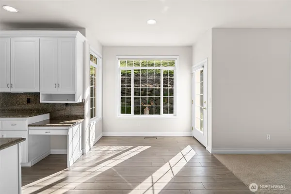 a view of a kitchen with a stove wooden cabinets and a refrigerator