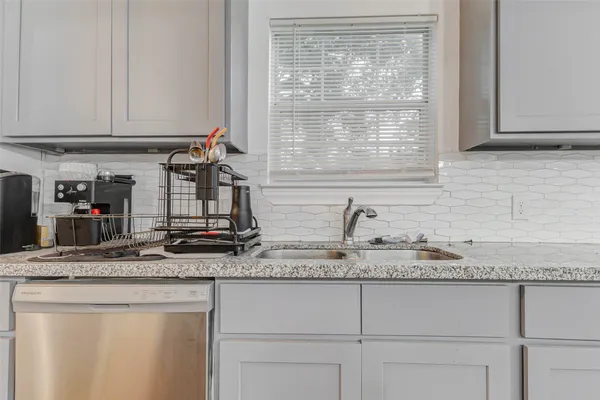 a kitchen with granite countertop cabinets sink and window