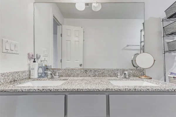 a bathroom with a granite countertop sink and a mirror