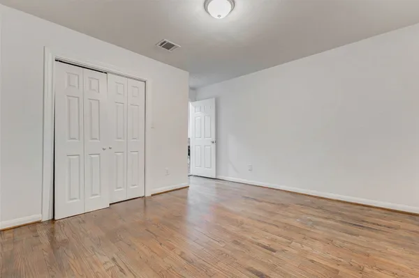 a view of an empty room with wooden floor