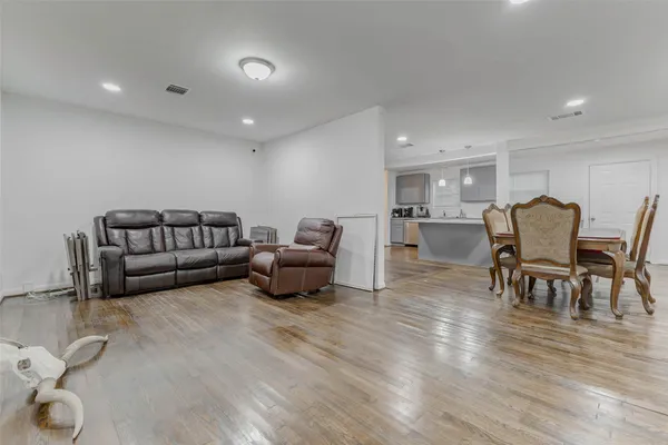 a living room with furniture and a wooden floor