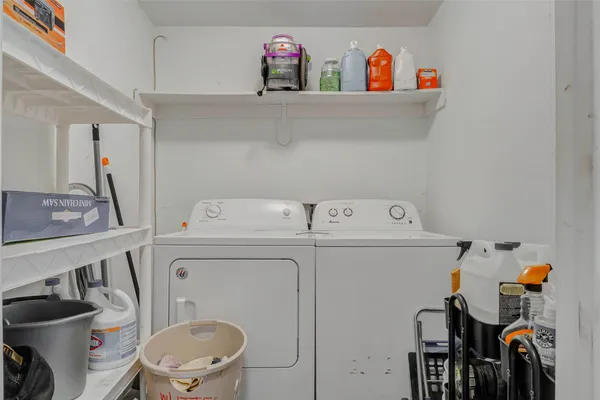 a utility room with dryer washer and a view of living room