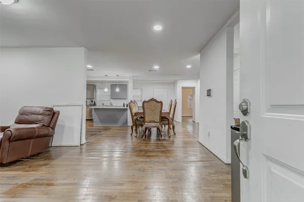 a living room with furniture and a dining table with kitchen view