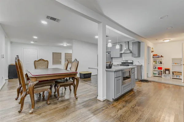 a kitchen with stainless steel appliances kitchen island wooden floors and white cabinets