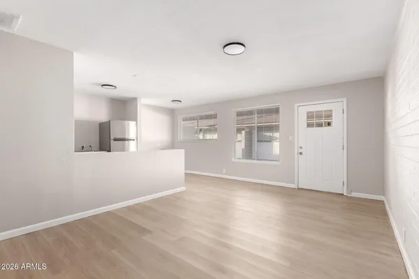 a view of empty room with wooden floor and windows