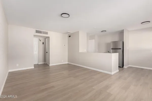 a view of empty room with wooden floor and window