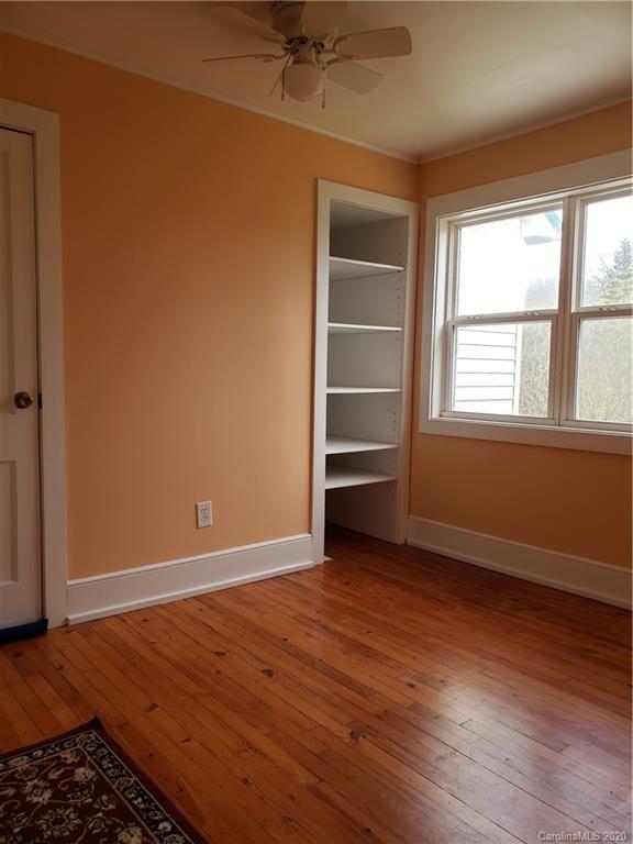 831 Dale Road Spruce Pine, NC 28777 - Photo 12 of 21 an empty room with wooden floor closet and windows