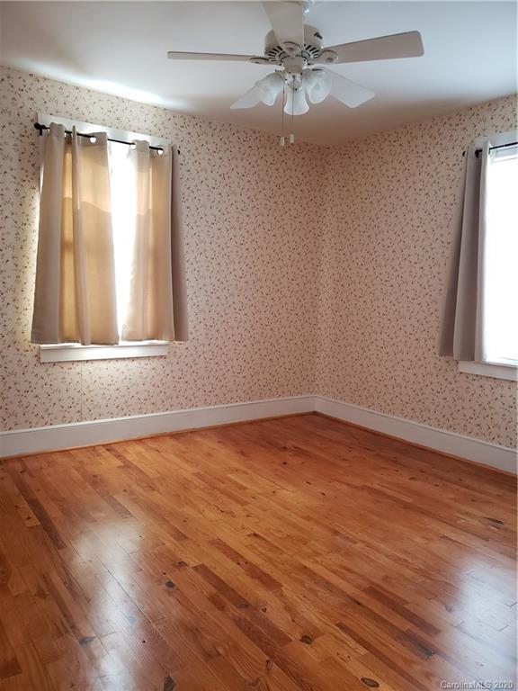 831 Dale Road Spruce Pine, NC 28777 - Photo 13 of 21 an empty room with wooden floor fan and windows