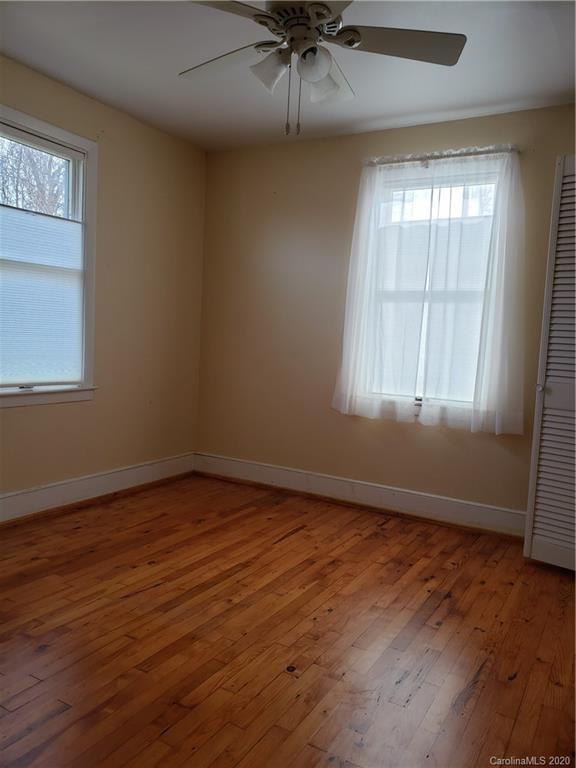 831 Dale Road Spruce Pine, NC 28777 - Photo 14 of 21 an empty room with wooden floor and windows