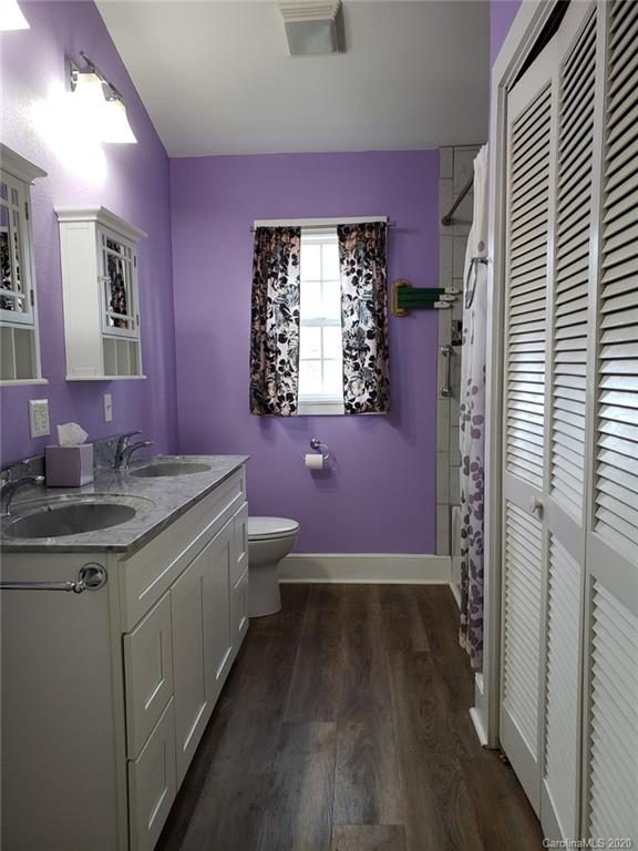 831 Dale Road Spruce Pine, NC 28777 - Photo 16 of 21 a spacious bathroom with a granite countertop sink a toilet a mirror and vanity