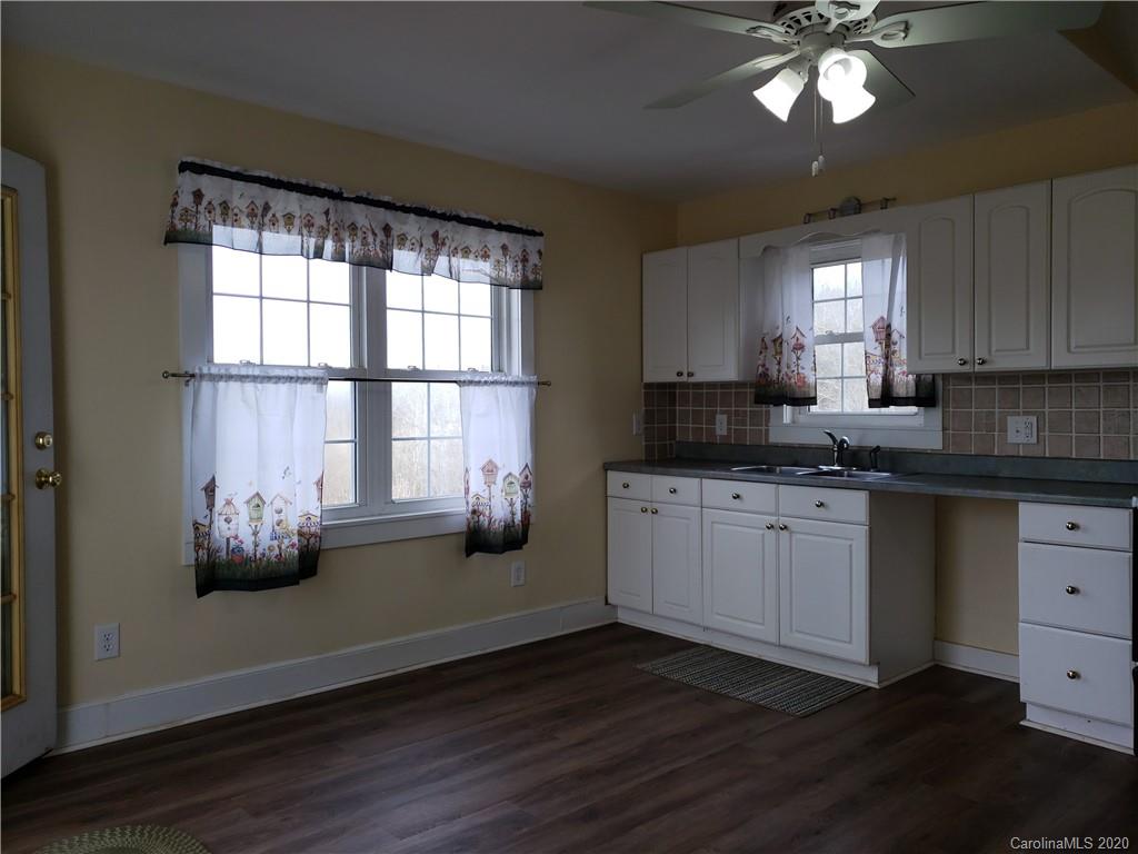 831 Dale Road Spruce Pine, NC 28777 - Photo 4 of 21 a kitchen with granite countertop a stove a sink and a window