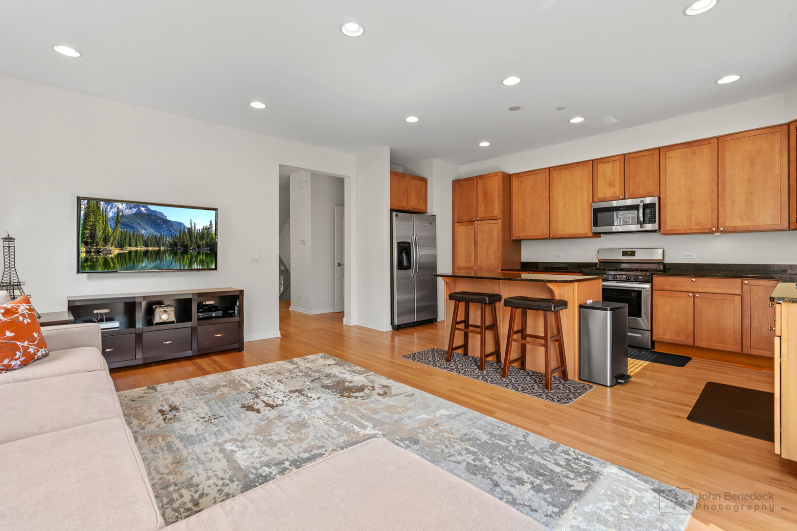220 River Front Drive Mount Prospect, IL 60056 - Photo 11 of 33 a open kitchen with stainless steel appliances granite countertop a stove top oven a sink a dining table and chairs with wooden floor